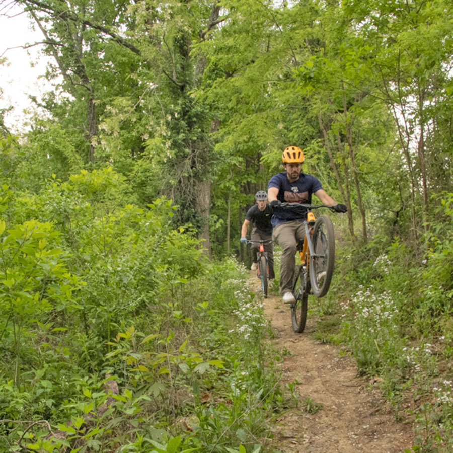 Members of the Evansville community enjoying the miles of mountain bike trails winding through the woods surrounding USI.