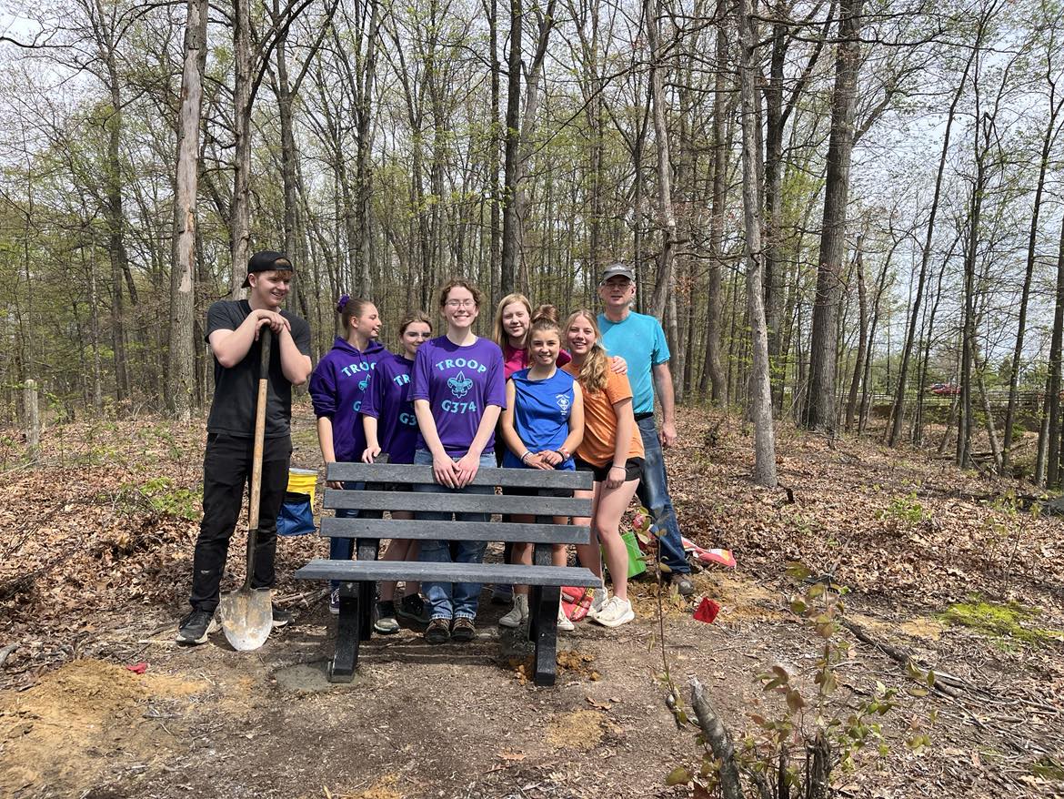 A Scouting Troop helps a fellow 2025 Eagle Scout install some benches on Bent Twig Trail. 
