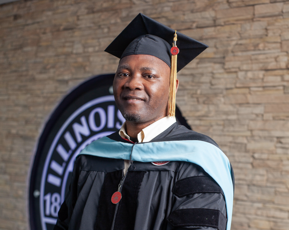 Somé wears a cap and gown to honor his educational achievements.