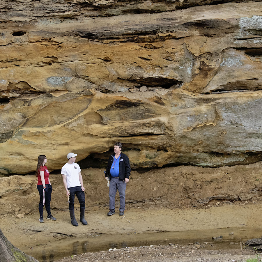 Geology students looking at the sandstone bluffs located on the south eastern side of campus.