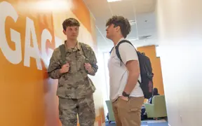 An ROTC student in the Business Engineering students stops to talk to a friend between classes.