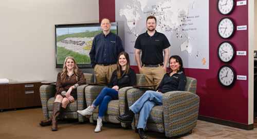 AstraZeneca Scholarship Committee poses in front of a global company map.