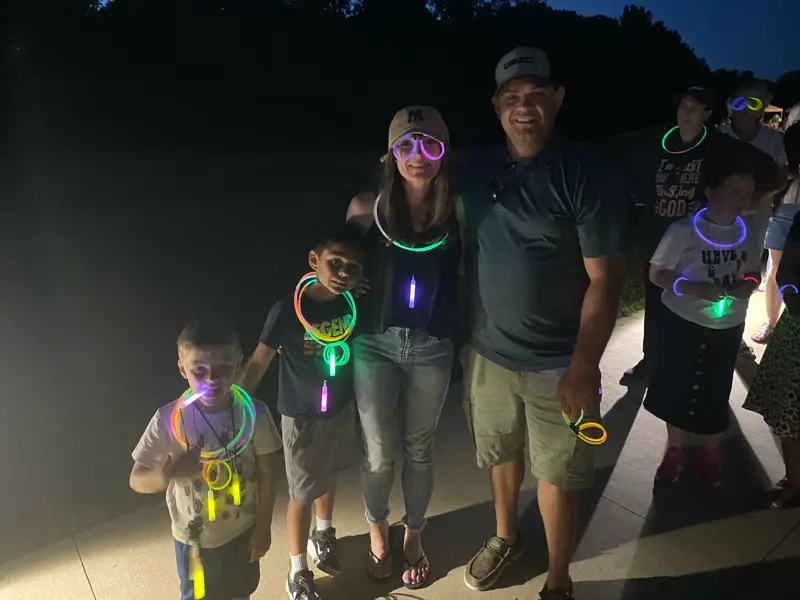 Group of attendees at night wearing glowing necklaces and bracelets.