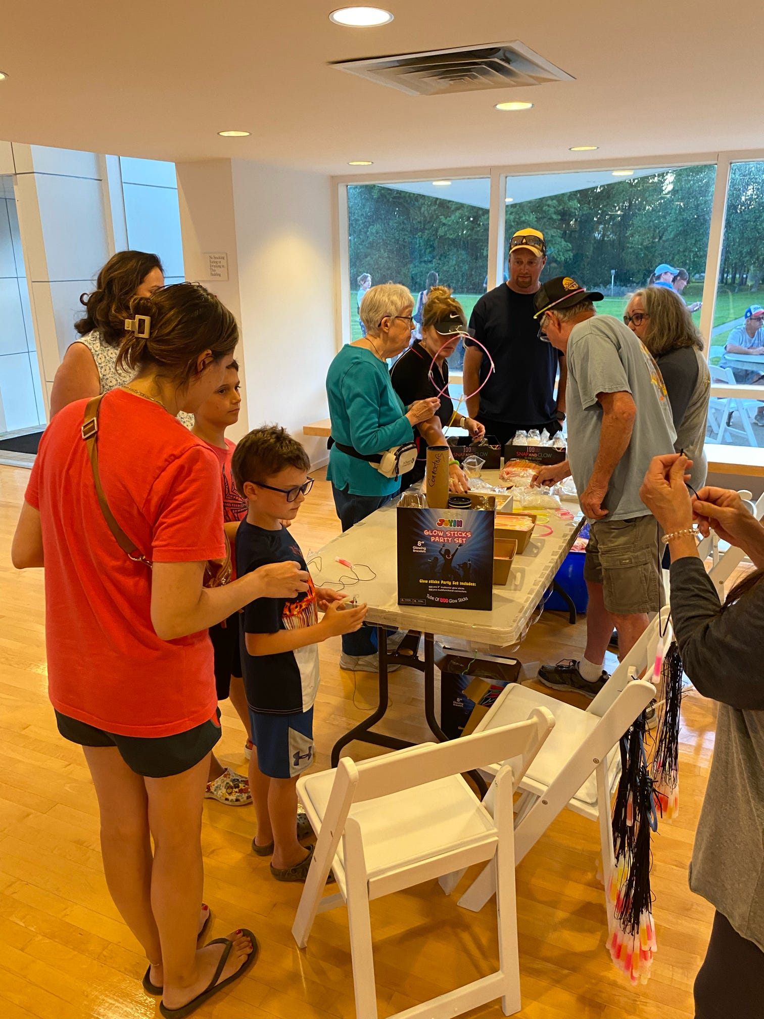 People interacting at a craft table with supplies and materials arranged across the surface.
