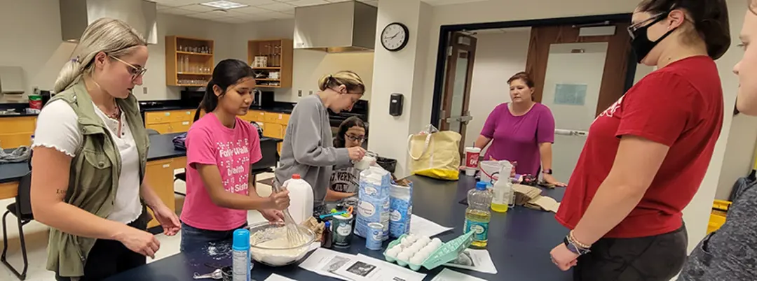 Students working with visitors in kitchen
