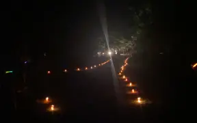 Nighttime pathway lined with small lights leading into the distance.