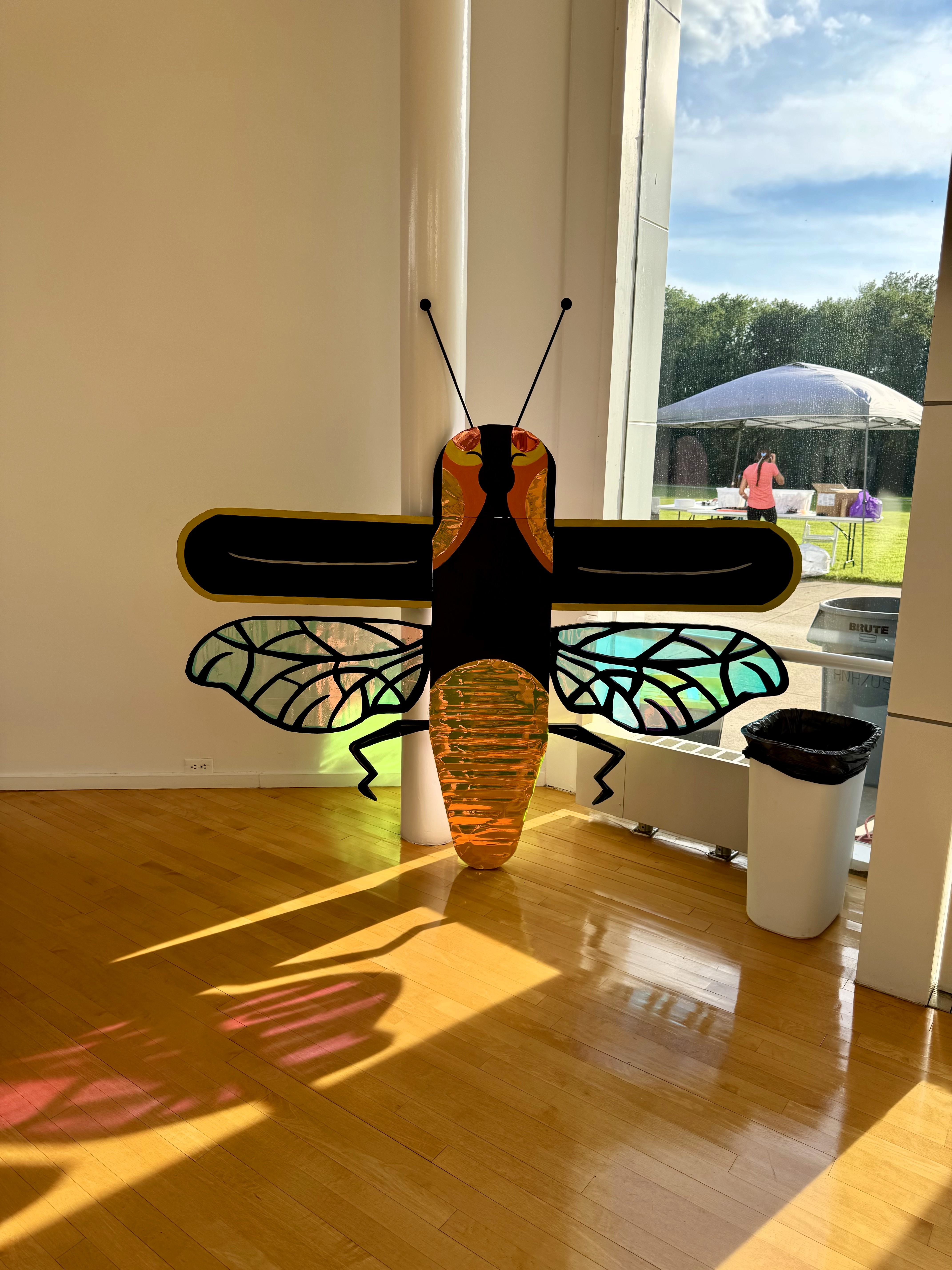 Light-up firefly sculpture with translucent wings displayed indoors on a table.