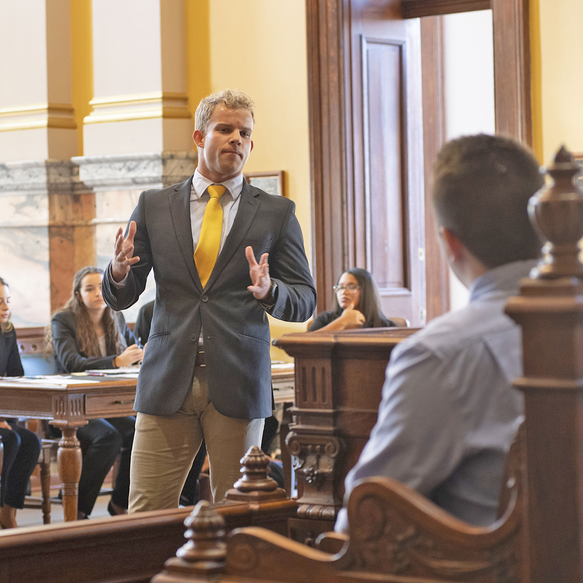 A prelaw student cross examines a witness during a mock trial held at a historic court house. 