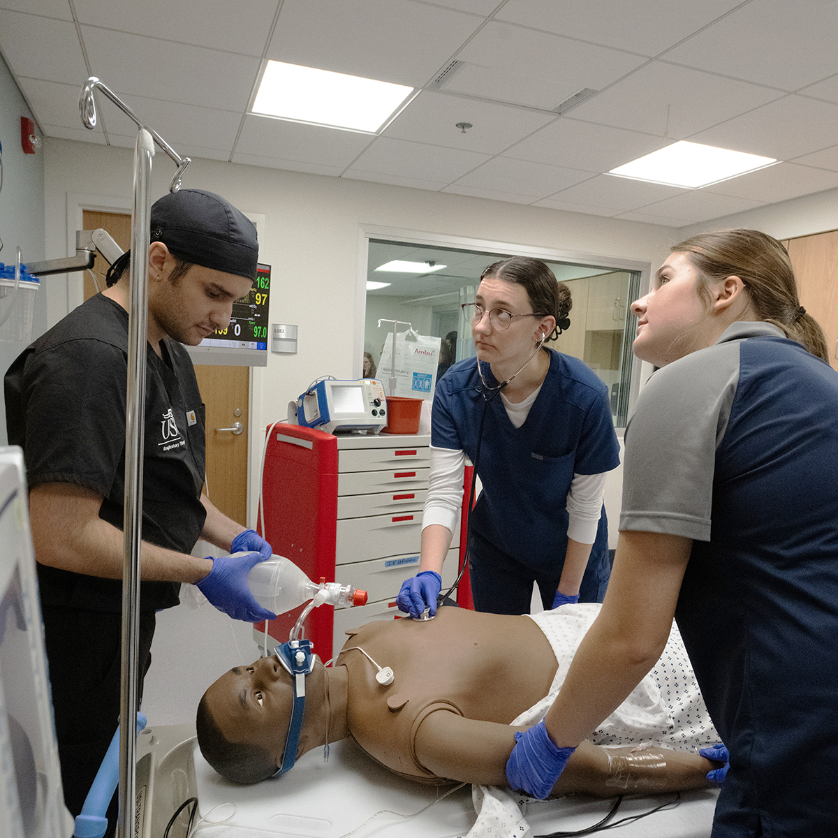Respiratory therapy, and nursing students monitor life signs and ventilate a patient in a collaborative SIM lab.
