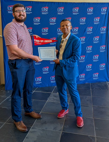 Dean handing Jaxon a certificate and pennant