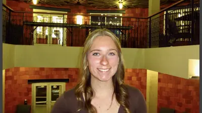 Casual portrait of Ally Patrick standing in the Fireside Lounge at USI