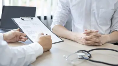 photo of caregiving pointing to a tablet with a patient