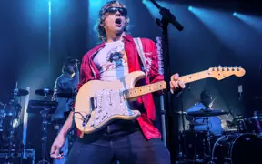 Ross Lynch on stage with a guitar.