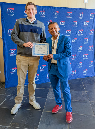 Dean handing Alex a certificate