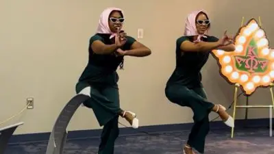Two sorority women posing during a new member presentation.
