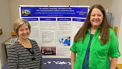 Two faculty members in front of a poster