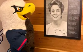 Archie by a framed photo of food pantry founder, Sandra Lawrence