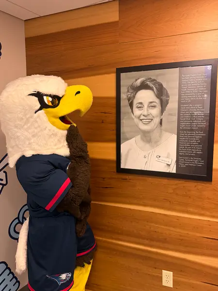 Archie by a framed photo of food pantry founder, Sandra Lawrence