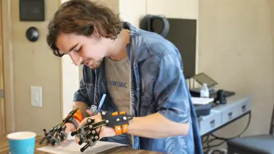 A student using arthritis simulation gloves while trying to write