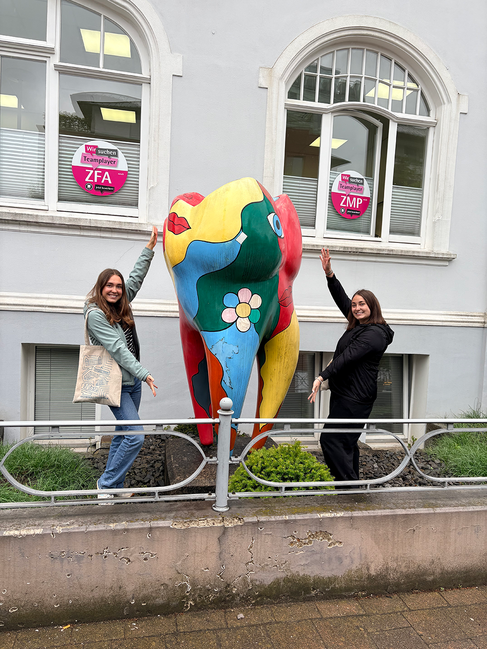 Students standing by statue in front of dental clinic