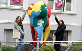 Students standing by statue in front of dental clinic