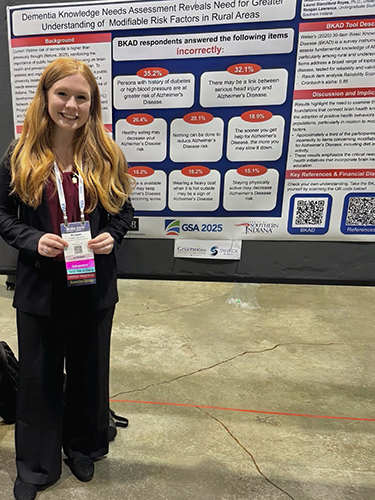 Reagan at a conference in front of her research poster