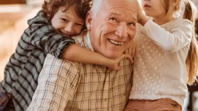 Photo of older adult with grandchildren