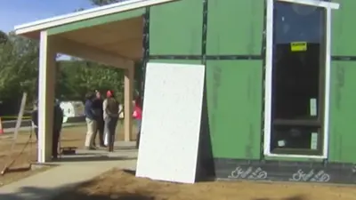 A group of engineering students survey the under construction Minka house for improvements