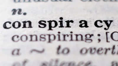 Up close view of the word "conspiracy" in a dictionary entry