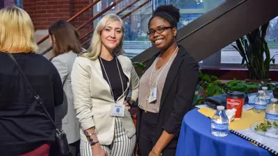 Psychology students in professional attire pose for a photo at a networking event