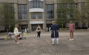 Students being instructed on fencing on brick in front of the Liberal Arts building.