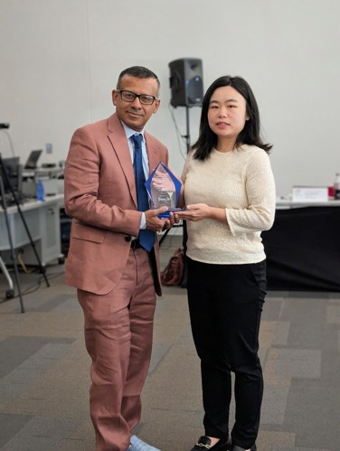 Dean handing Dr. Liu her award at the Board of Advisors spring meeting