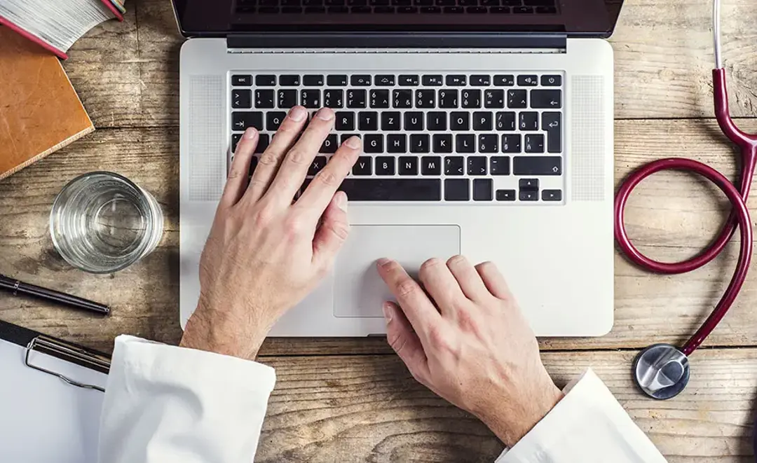 A first-person perspective view of hands on a laptop keyboard