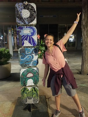 Malaika in front of statue