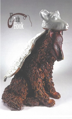 A picture of a sculpture of a brown wolf with a sheep's head and hide laying on top of it.