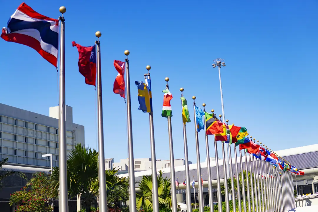 Row of flagpoles with flags from all over the world
