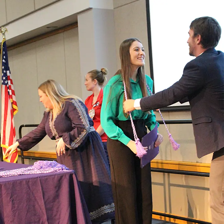 student getting the honor society tassel