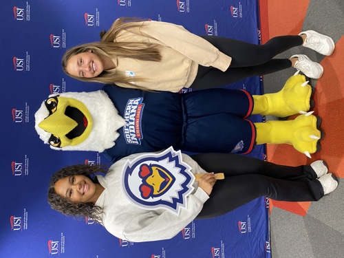 Two students with Archie Eagle at Health Profesisons Day
