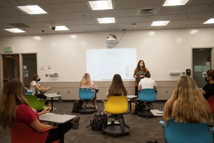 Students in a class lecture wearing face masks paying attention to the instructor