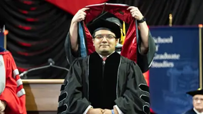 Cesar Berrios gets hooded for his graduate degree
