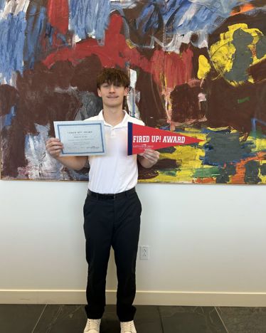 Alex holding a certificate and pennant
