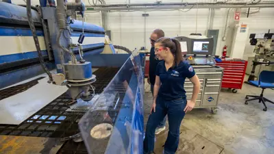 Two students watching water jet machine 