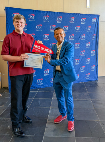 Dean handing Jacob a certificate and pennant