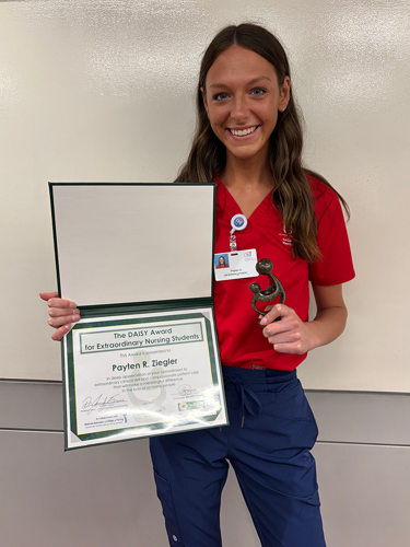 Payten Ziegler, Daisy Recipient, holding a certificate