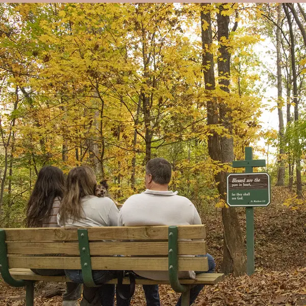 A family and small dog, pauses and reflects over the signage found on the Meditation Trail. 