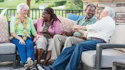 Older adults sit on a patio and converse