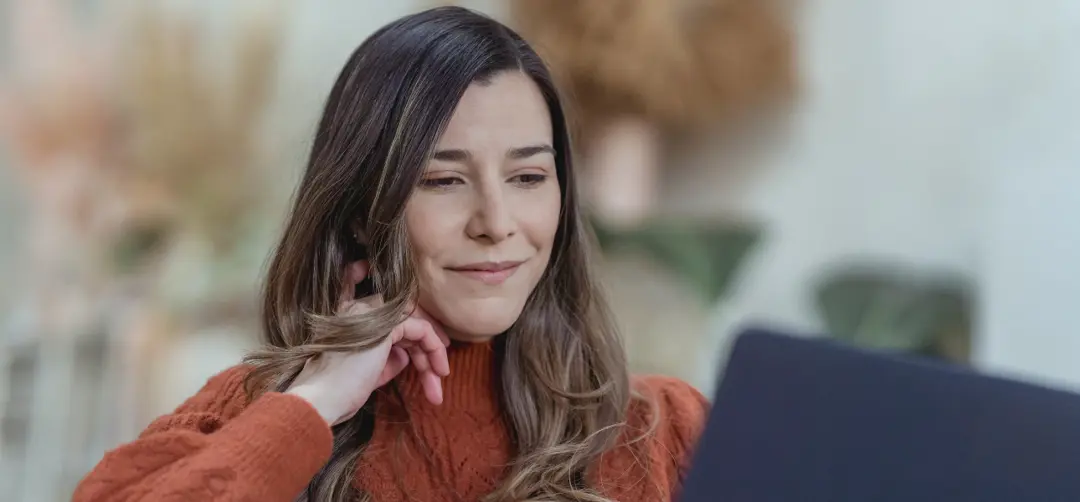 Adult female student smiles while working on a laptop