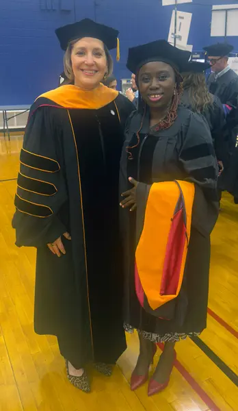 Jennifer Evans poses with student at graduation