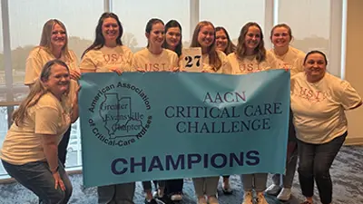 Nursing students holding a banner at the competition