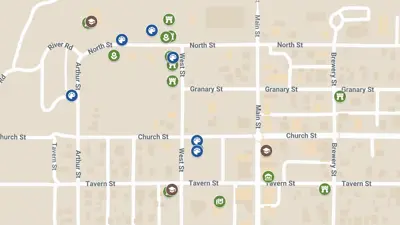 A map of New Harmony shows labeled streets and clusters of colored icons marking locations of historic sites, museums, and public art throughout the town.